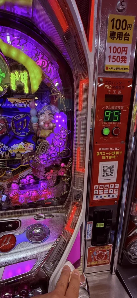 ゲームセンターのパチンコ台に設置されたQRコード決済用の案内と読み取り機